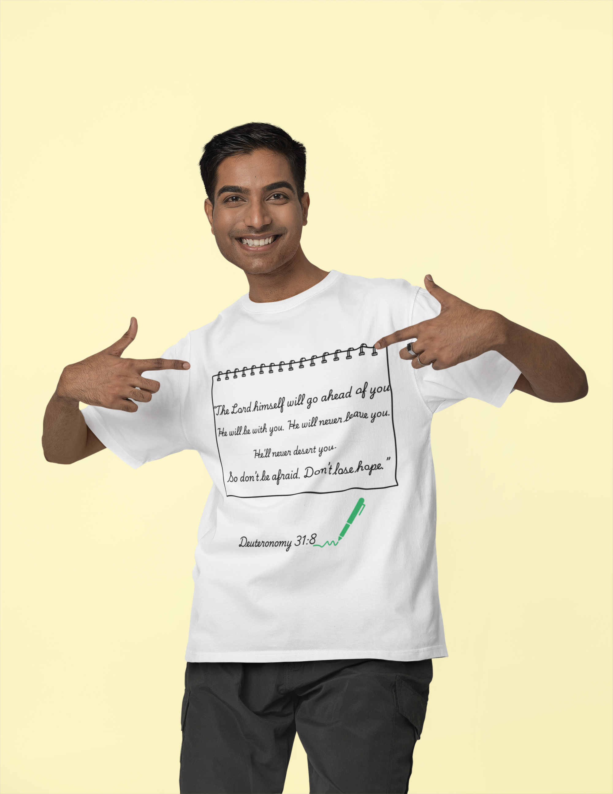 Man wearing a white t-shirt with text and pointing to it, on a beige background