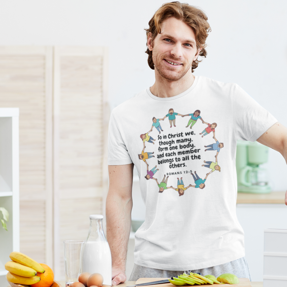 Man wearing a white t-shirt with a colorful graphic and text, standing in a kitchen.