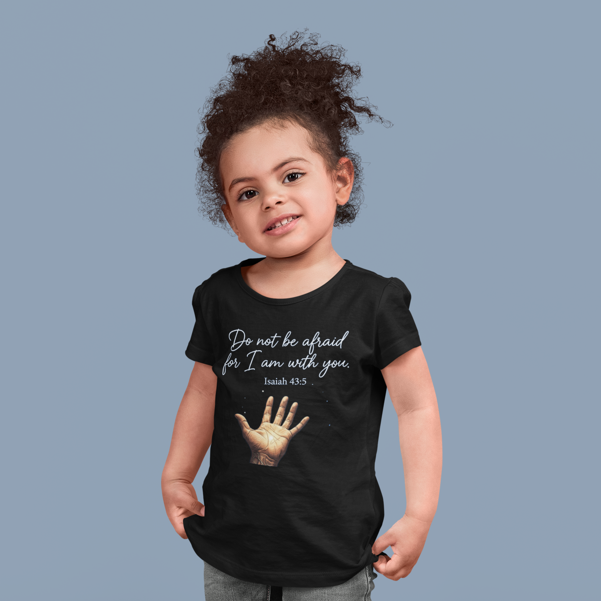 Child wearing a black t-shirt with a motivational quote and hand graphic on a solid background