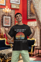 Man wearing a black t-shirt with a graphic and text, standing in an ornate room.