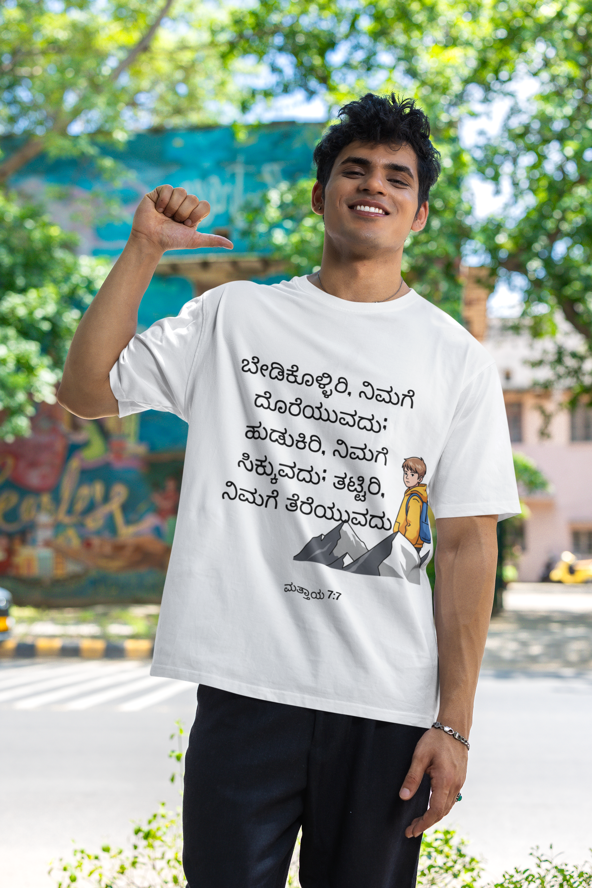 Person wearing a white t-shirt with text and graphics, standing outdoors.