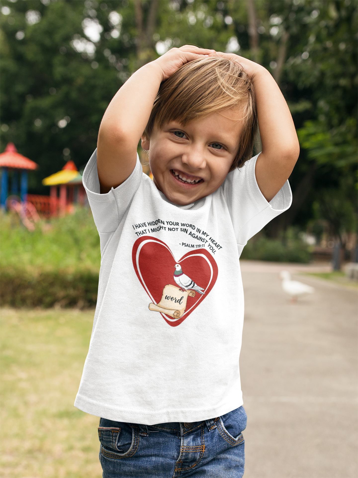 Child wearing a white t-shirt with a red heart design outdoors