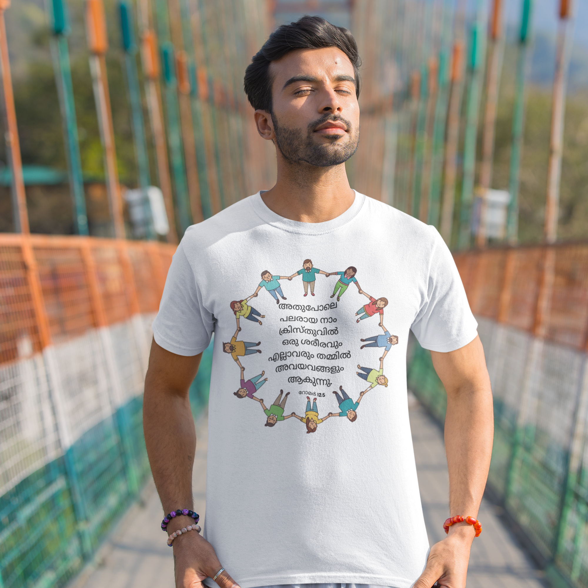 Man wearing a white t-shirt with a colorful graphic design on a bridge