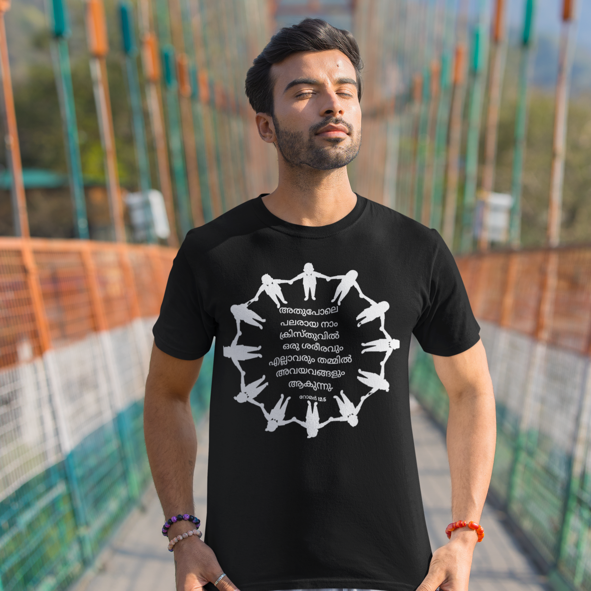 Man wearing a black t-shirt with a white graphic design on a bridge