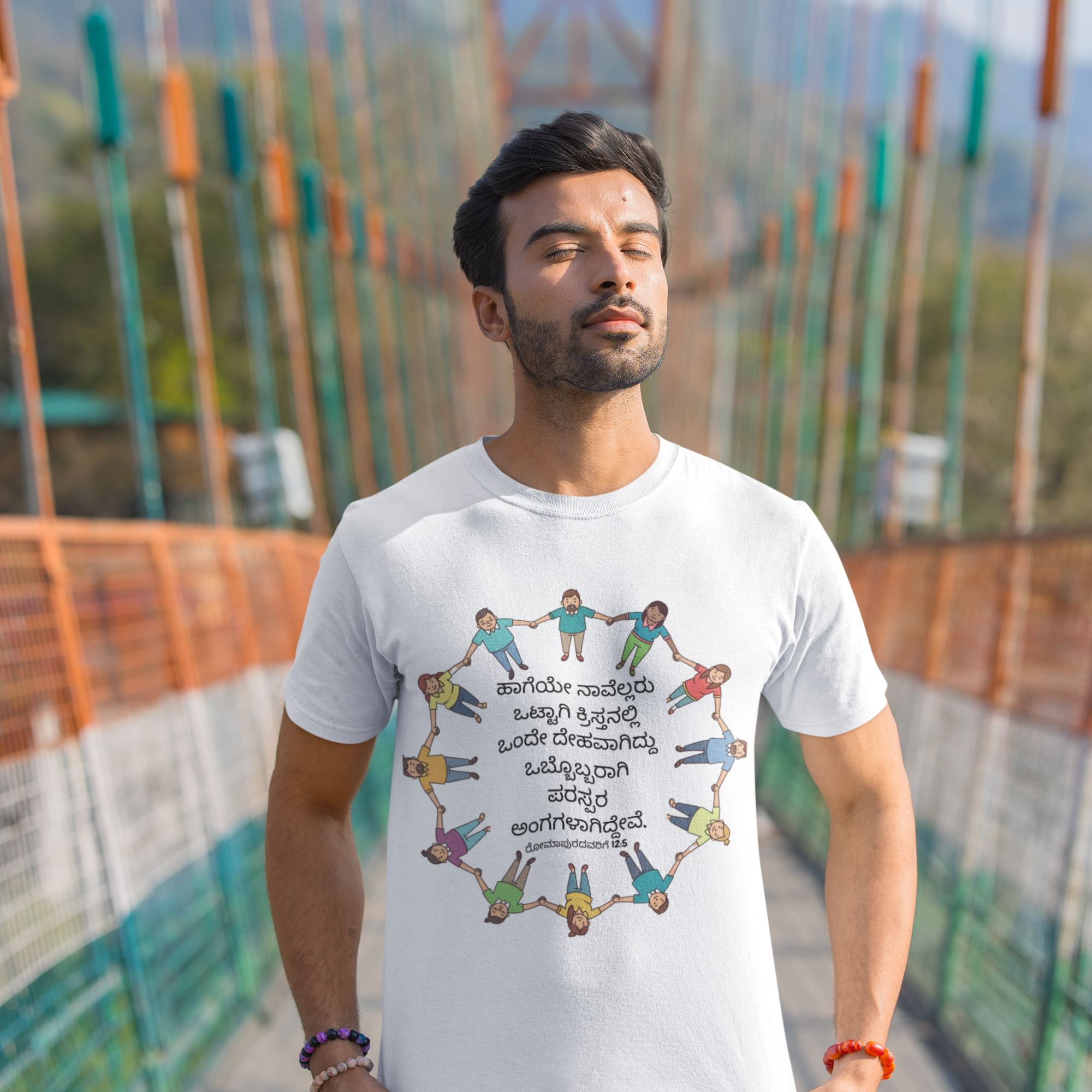 Man wearing a white t-shirt with a colorful design on a bridge
