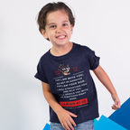 Child wearing a dark blue t-shirt with text and graphics, standing on a blue geometric surface.