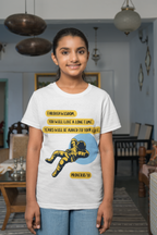 Person wearing a white t-shirt with a graphic design and text in a room.