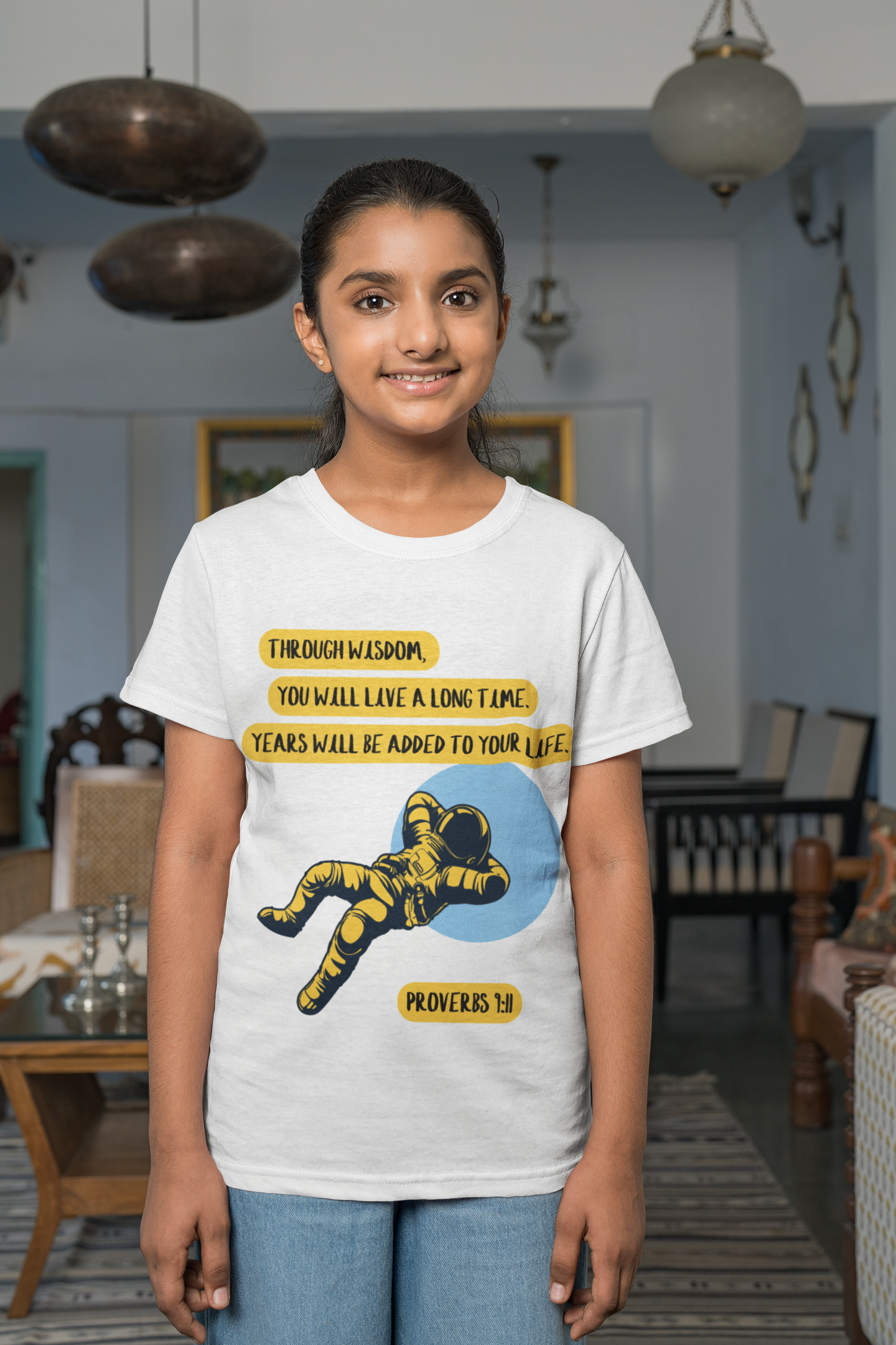 Person wearing a white t-shirt with a graphic design and text in a room.