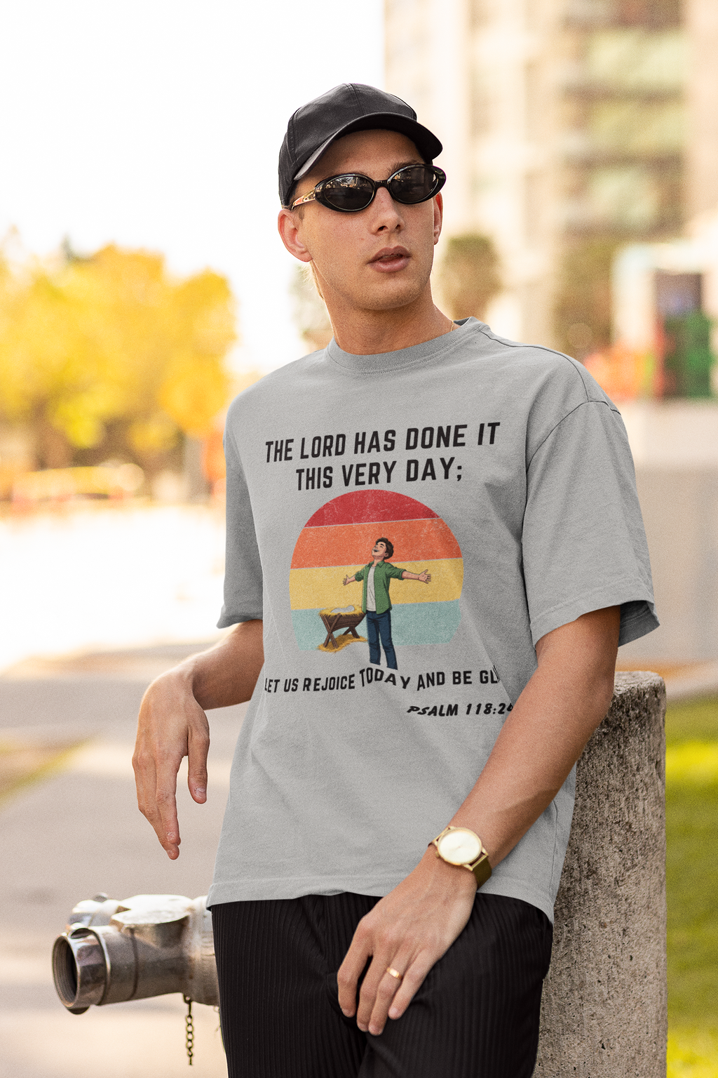 Man wearing a gray t-shirt with a printed design, standing outdoors.