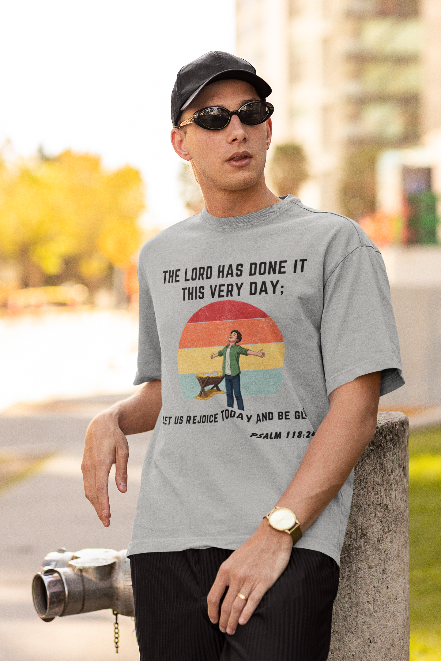 Man wearing a gray t-shirt with a printed design, standing outdoors.