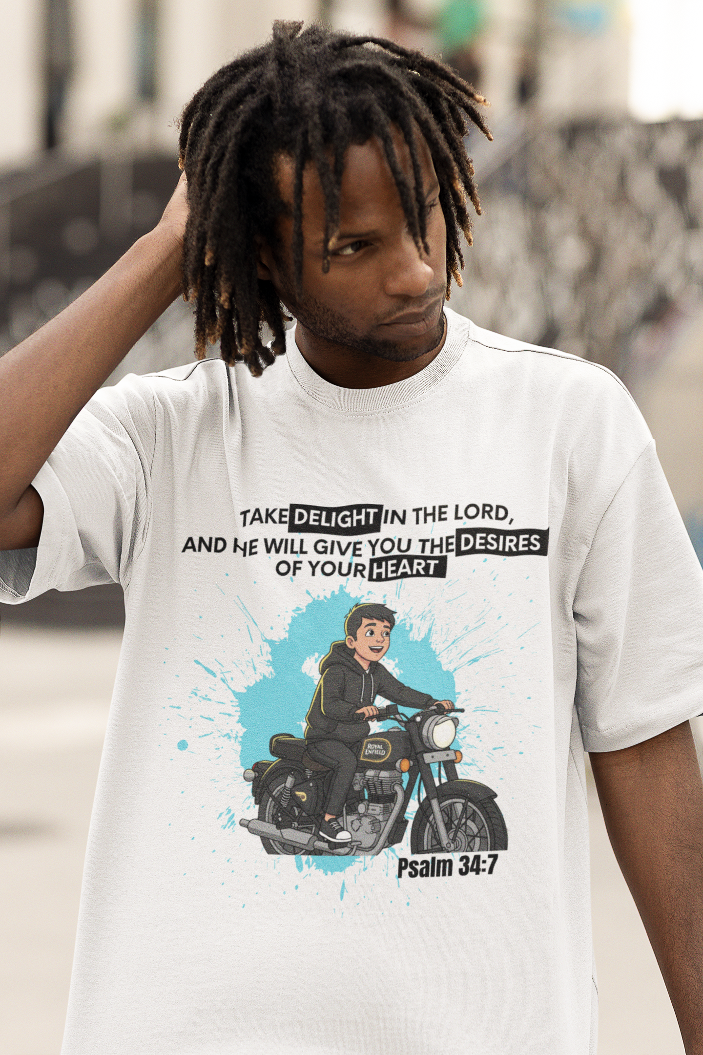 Person wearing a white t-shirt with a graphic and text, standing outdoors.