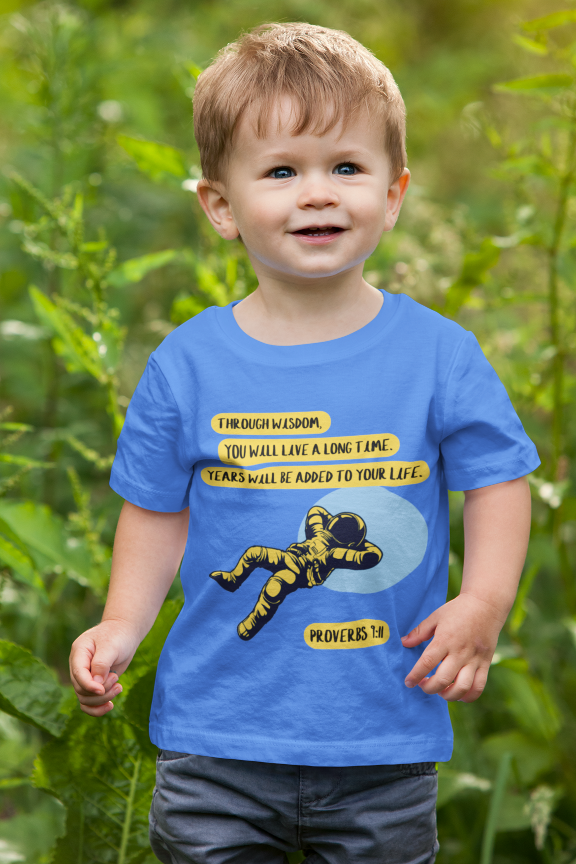 Child wearing a blue t-shirt with a graphic design outdoors