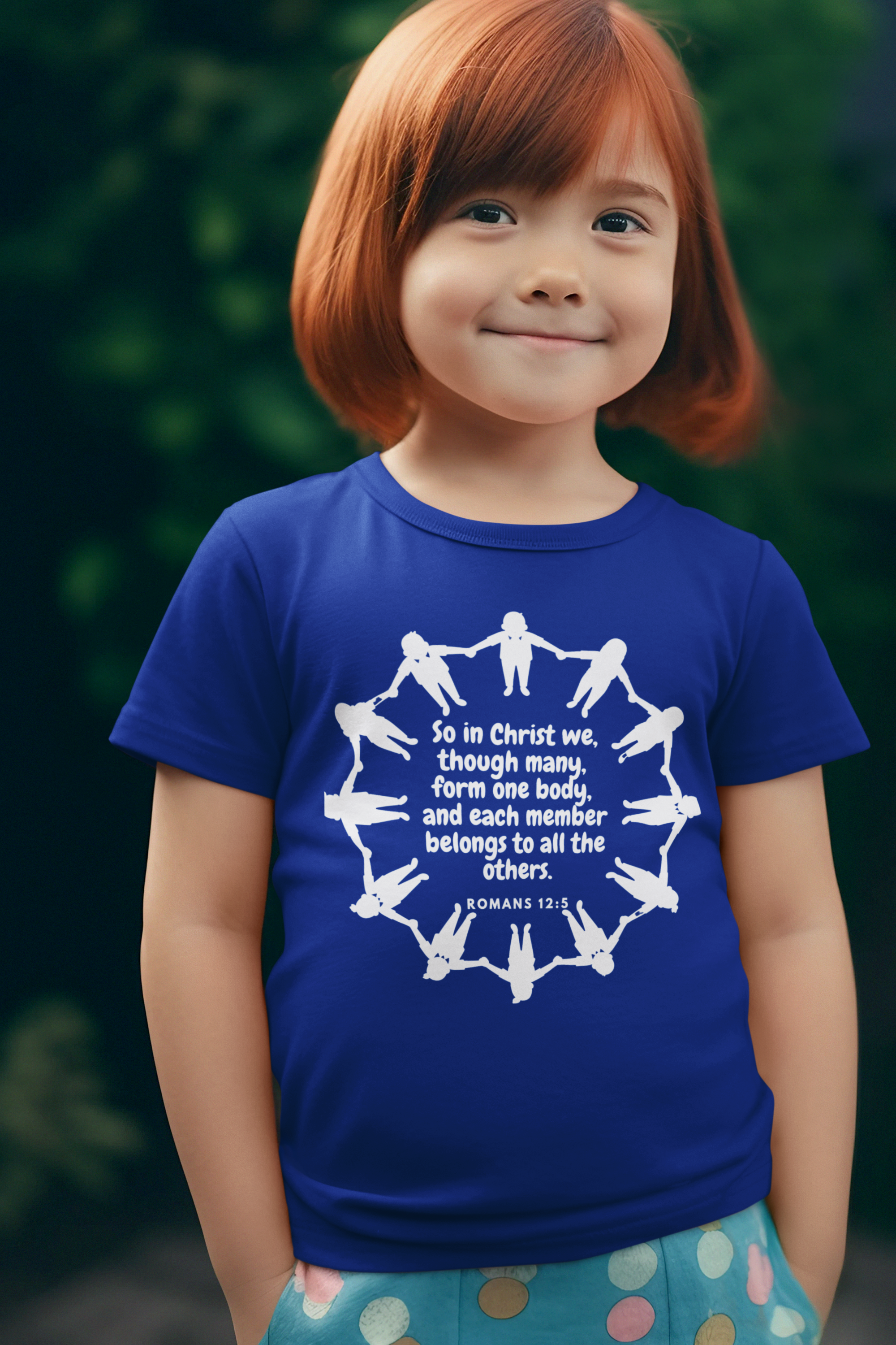 Child wearing a blue t-shirt with a white graphic and text, standing outdoors.