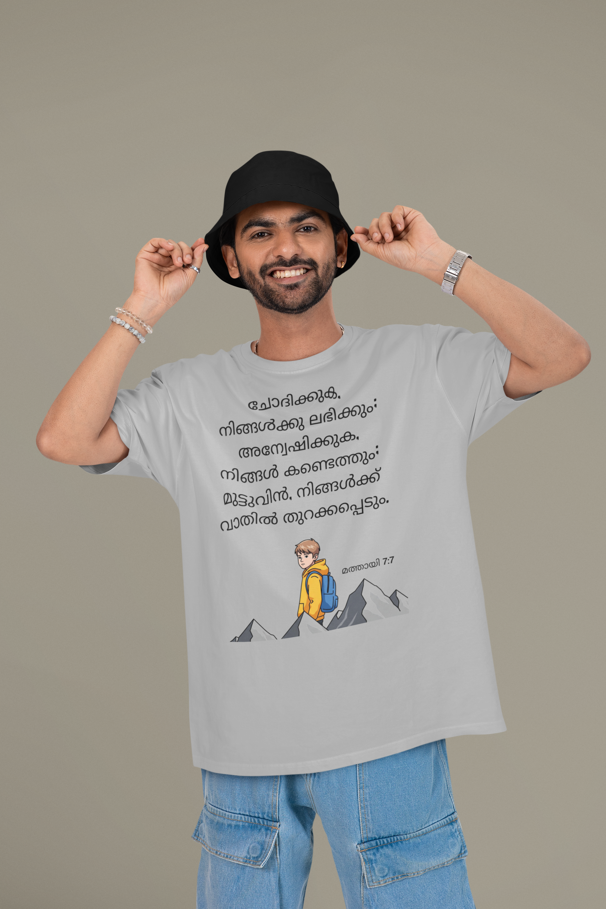 Man wearing a gray t-shirt with a graphic and text, standing against a plain background