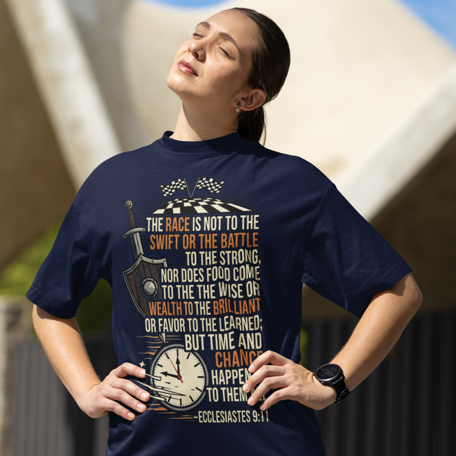 Woman wearing a navy blue t-shirt with text and graphics, standing outdoors.