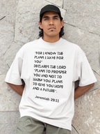 Man wearing a white t-shirt with a biblical quote against a stone wall background