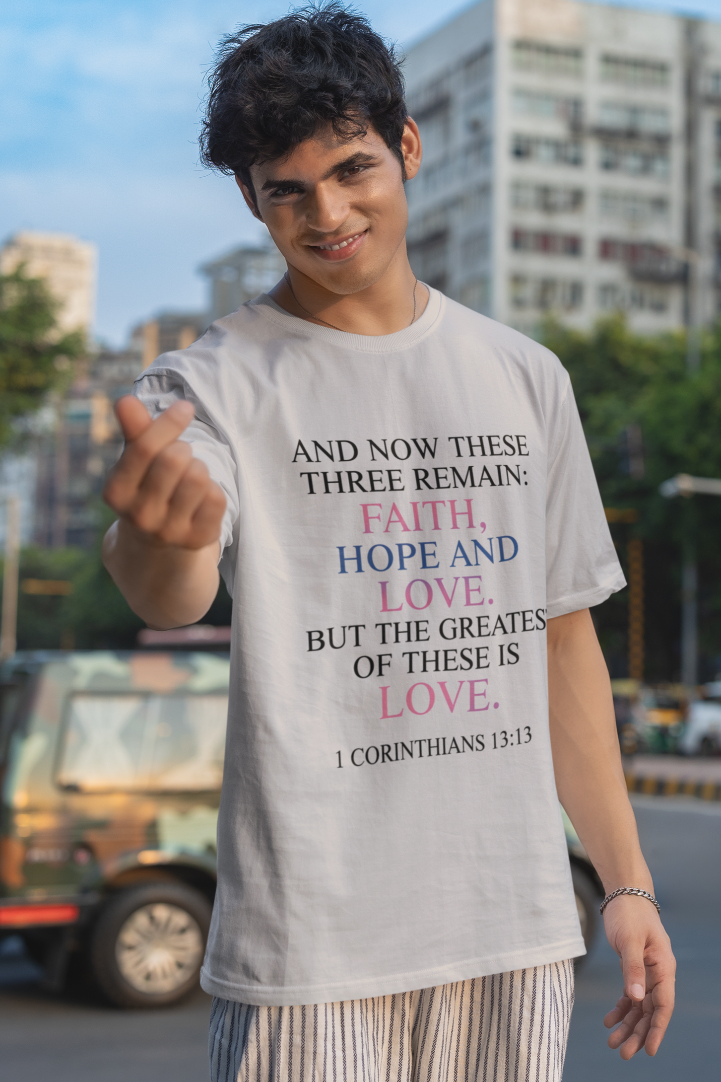 Person wearing a t-shirt with a motivational quote on a city street.