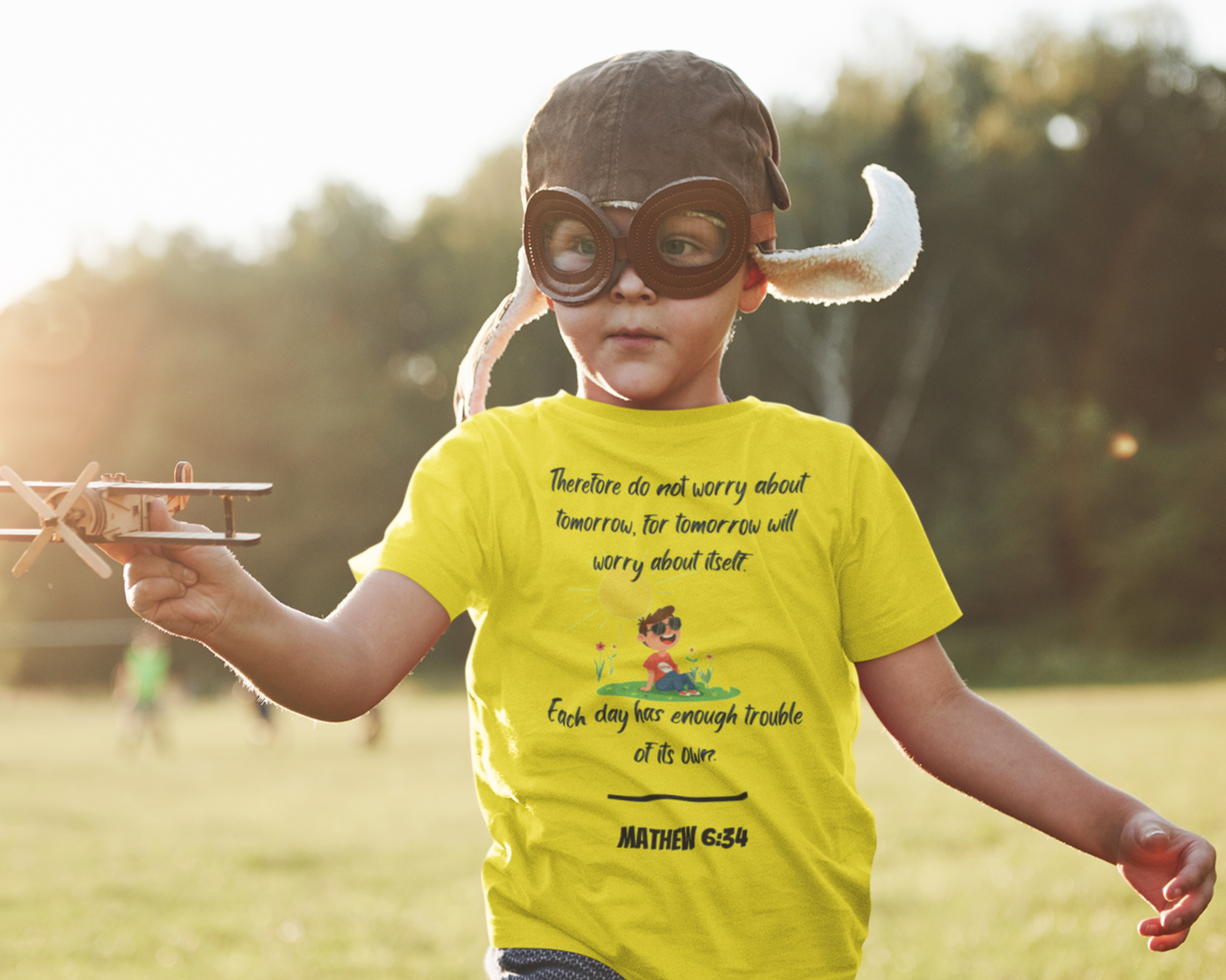 Child in a superhero costume with a yellow t-shirt outdoors